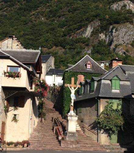 a statue of a cross on the top of some stairs at Les Deux Rives in Cierp