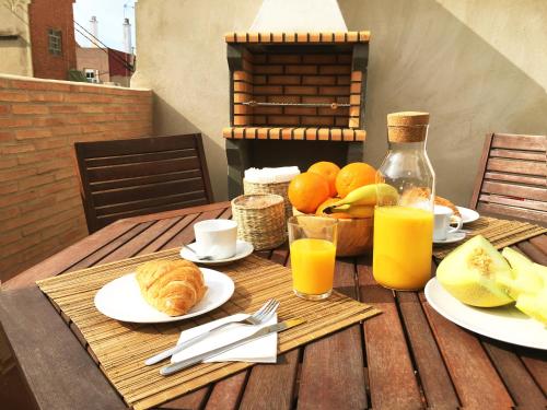 a wooden table with breakfast foods and orange juice at Ático cerca del mar in Valencia