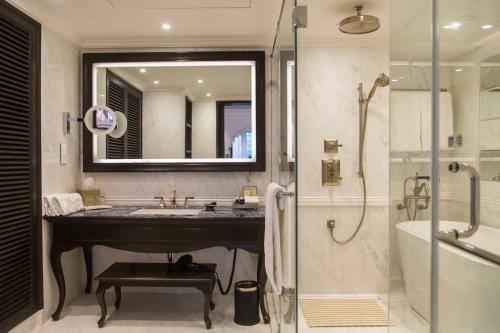 a bathroom with a sink and a shower and a mirror at Taj Bengal in Kolkata