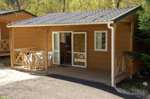 a large wooden cabin with a large deck at Camping La Ferme de Castellane in Castellane