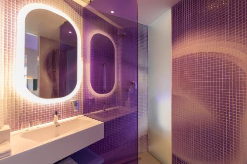 a bathroom with a sink and three mirrors at Park Inn by Radisson Amsterdam City West in Amsterdam