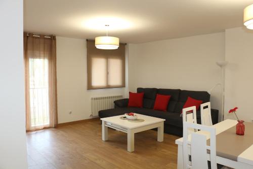 a living room with a black couch and a table at Apartamentos Homelife Roca Tarpeya in Toledo