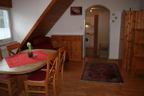 a dining room with a table and chairs and a kitchen at Ferienwohnungen Porisch in Egloffstein