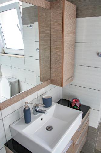 a bathroom with a white sink and a mirror at Catherine's Comfort Apartment Νο3 in Lávrion