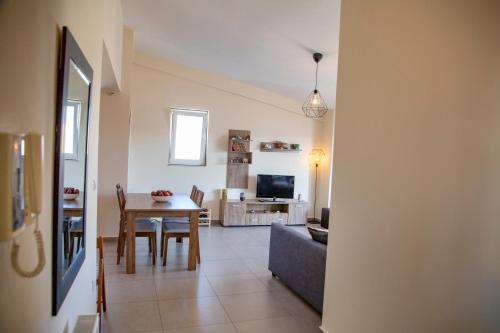 a dining room and living room with a table and a couch at Catherine's Comfort Apartment Νο3 in Lavrio
