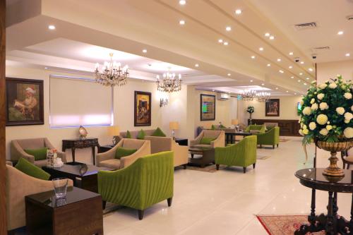 a lobby with green chairs and a waiting room at City Rose Hotel Suites in Amman