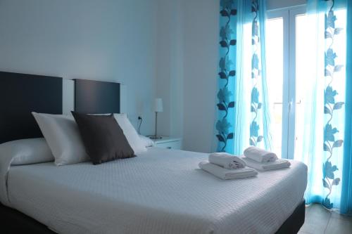 トレドにあるApartamentos Homelife Roca Tarpeyaのベッドルーム1室(ベッド1台、タオル2枚付)