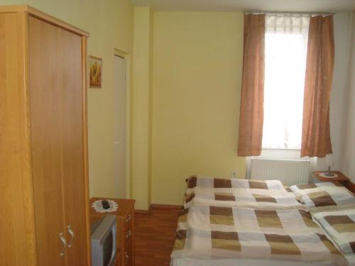 a small bedroom with a bed and a window at Penzion Adria in Turčianske Teplice
