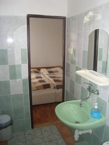 a bathroom with a sink and a bed at Penzion Adria in Turčianske Teplice