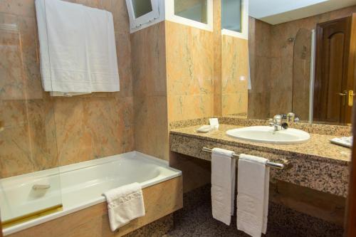 a bathroom with a bath tub and a sink at Hotel Europa in Albacete