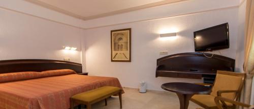 a hotel room with a bed and a flat screen tv at Hotel Europa in Albacete