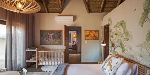 a bedroom with a bed and a living room at Nkala Safari Lodge in Matlhagame