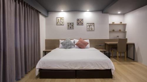 a bedroom with a bed and a desk and a table at Toptel Thaphra - ท็อปเทล ท่าพระ in Bangkok