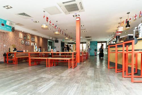 a restaurant with orange benches and tables in a room at YHA London Central in London