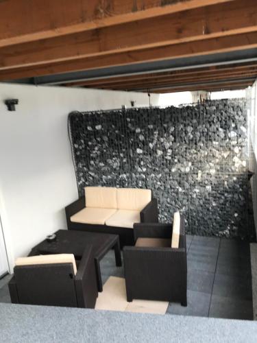 een woonkamer met banken en een stenen muur bij Einliegerwohnung mit Terrasse in Friedrichshafen