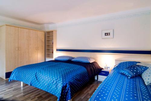 a bedroom with two beds with blue comforters at Hiša posebne Sorte in Kodreti