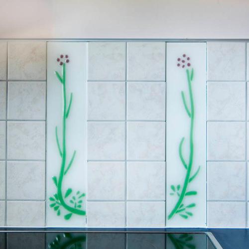 two tiles with flowers on the wall of a bathroom at Hiša posebne Sorte in Kodreti