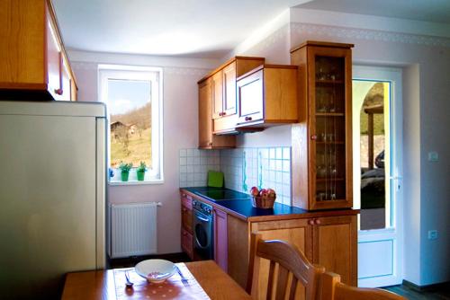 a kitchen with wooden cabinets and a wooden table with a tableablish at Hiša posebne Sorte in Kodreti