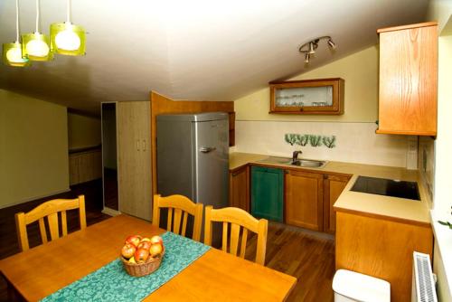 a kitchen with a table with a bowl of apples on it at Hiša posebne Sorte in Kodreti