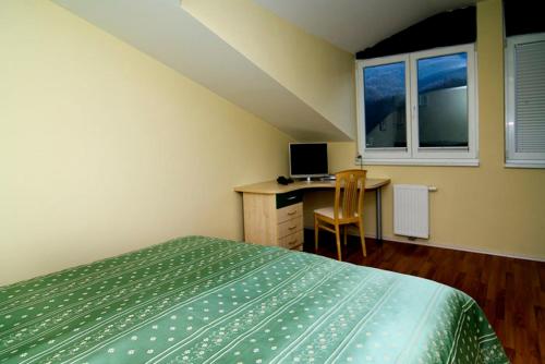 a bedroom with a bed and a desk with a computer at Hiša posebne Sorte in Kodreti