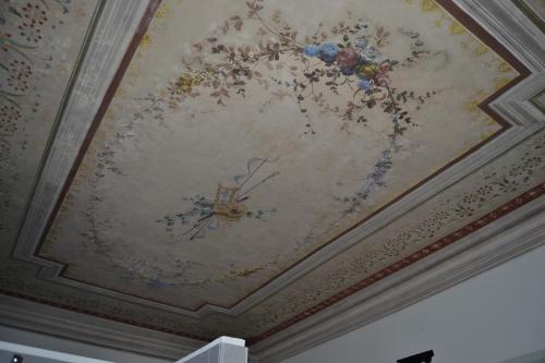 a ceiling with a painting of flowers on it at Palazzo Roberti in Monte San Giusto