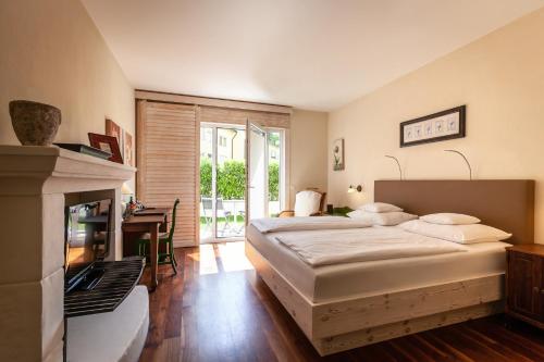a bedroom with a large bed and a fireplace at Hotel Hirschen in Freiburg-Lehen in Freiburg im Breisgau