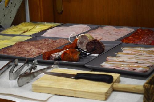 a table with different types of meats and cheese at Hostal Vall D'Aneu by Arcas & Sambola in Esterri d'Àneu