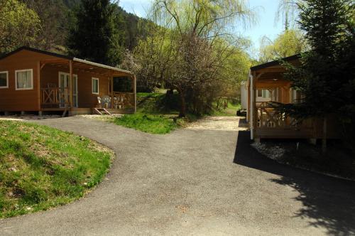 a cabin with a driveway next to a house at Camping La Ferme de Castellane in Castellane