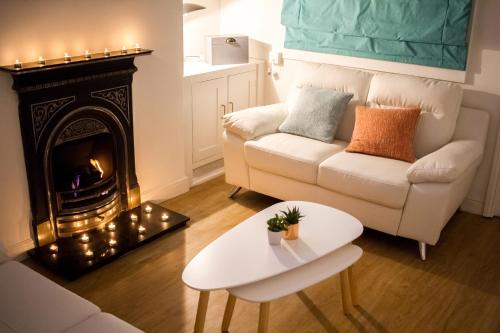 a living room with a white couch and a fireplace at Secret City Courtyard Cottage Within Chester City Walls in Chester