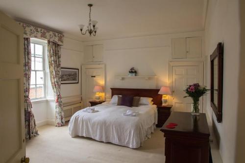 1 dormitorio con 1 cama blanca y 2 lámparas en East Pallant Bed and Breakfast, Chichester en Chichester