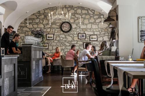 a group of people sitting at tables in a restaurant at LaBor Kvártély in Tokaj