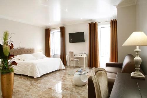 a bedroom with a bed and a couch and a table at Le Magnolia in Calvi