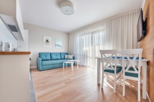 a living room with a blue couch and a table at Wczasowa, Sun & Snow in Ustka