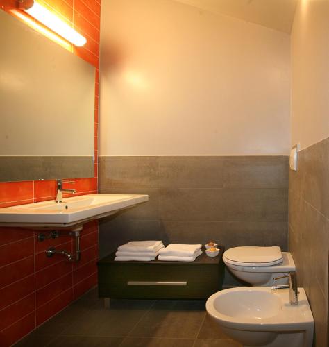 a bathroom with a sink and a toilet and a mirror at Residence Sottovento in Rimini