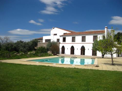 a large white house with a swimming pool in front of it at Convento da Provença in Portalegre