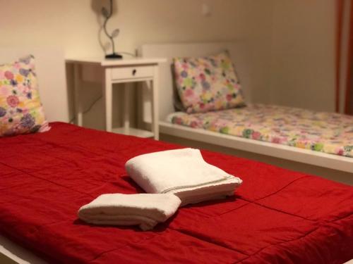 een rood bed met twee witte handdoeken erop bij Varandas da Barreta in Olhão