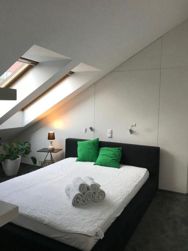 Apartament "WARSZAWA" في وارسو: غرفة نوم بسرير كبير ومخدات خضراء