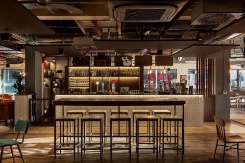 a bar in a restaurant with chairs and tables at ibis Styles Glasgow Central in Glasgow