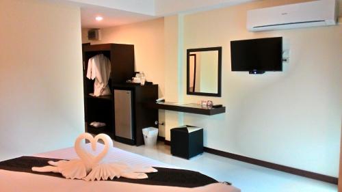 Habitación con decoración de cisne en una cama en K2 Living Hotel, en Uttaradit