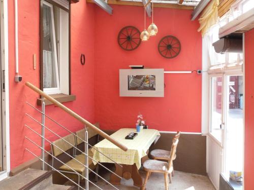 a dining room with red walls and a table and chairs at Ferienwohnung Familie Rudolf in Coswig