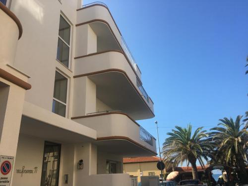 a white building with a balcony on the side of it at Via Firenze 11 in Follonica
