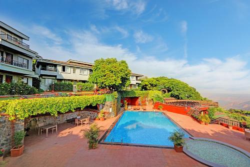 a resort with a swimming pool and a building at Ramsukh Resorts and Spa in Mahabaleshwar