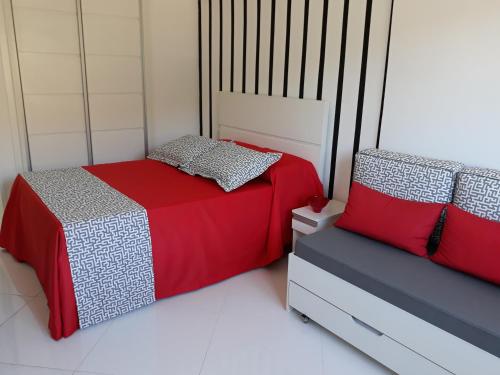 a bedroom with two beds with red and gray sheets at Flats Cavalinho Branco 405 ou 603 in Águas de Lindoia