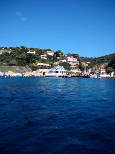 un bateau dans une grande étendue d'eau dans l'établissement Les Bambous, camping naturiste, sur l'Île du Levant