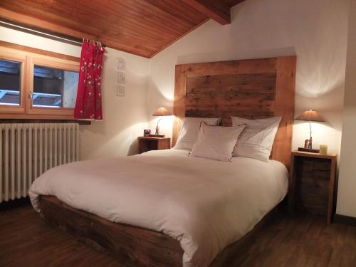 a bedroom with a large bed with a wooden headboard at Edelweiss in Les Gets