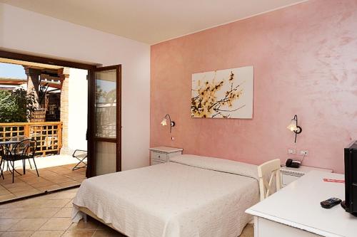 a bedroom with a bed and a patio with a table at Corte In Fiore in Ardea