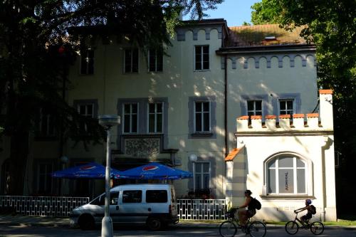 two people riding bikes in front of a building at Leier apartments in Piešťany