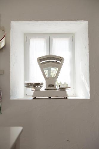 a window with a hair dryer sitting on a shelf at Casa dos Junqueiros - Countryside Guest House in Caldas da Rainha