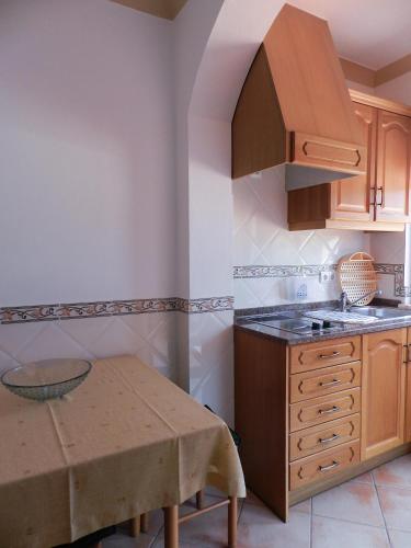 a kitchen with a wooden table and a counter top at Residencia Julio in Sagres