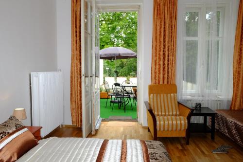 a bedroom with a bed and a chair and a patio at Leier apartments in Piešťany